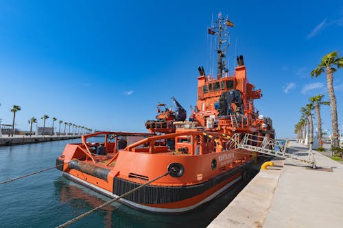 A large orange boat docked at a dock