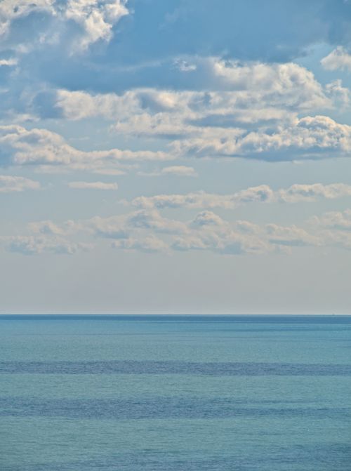 Free Tranquil seascape featuring a calm ocean and a sky filled with clouds, perfect for peaceful settings. Stock Photo