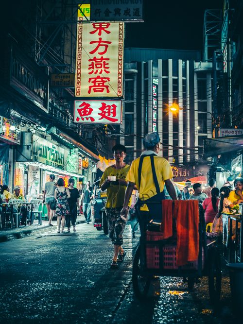 Free Bustling night market in Bangkok with vibrant lights and people shopping and dining. Stock Photo