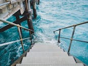 金属楼梯向下进入清澈碧绿的海水，非常适合旅行灵感