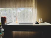 现代极简主义办公桌，配有笔记本电脑、鼠标和窗前的马克杯，是理想工作空间的灵感来源