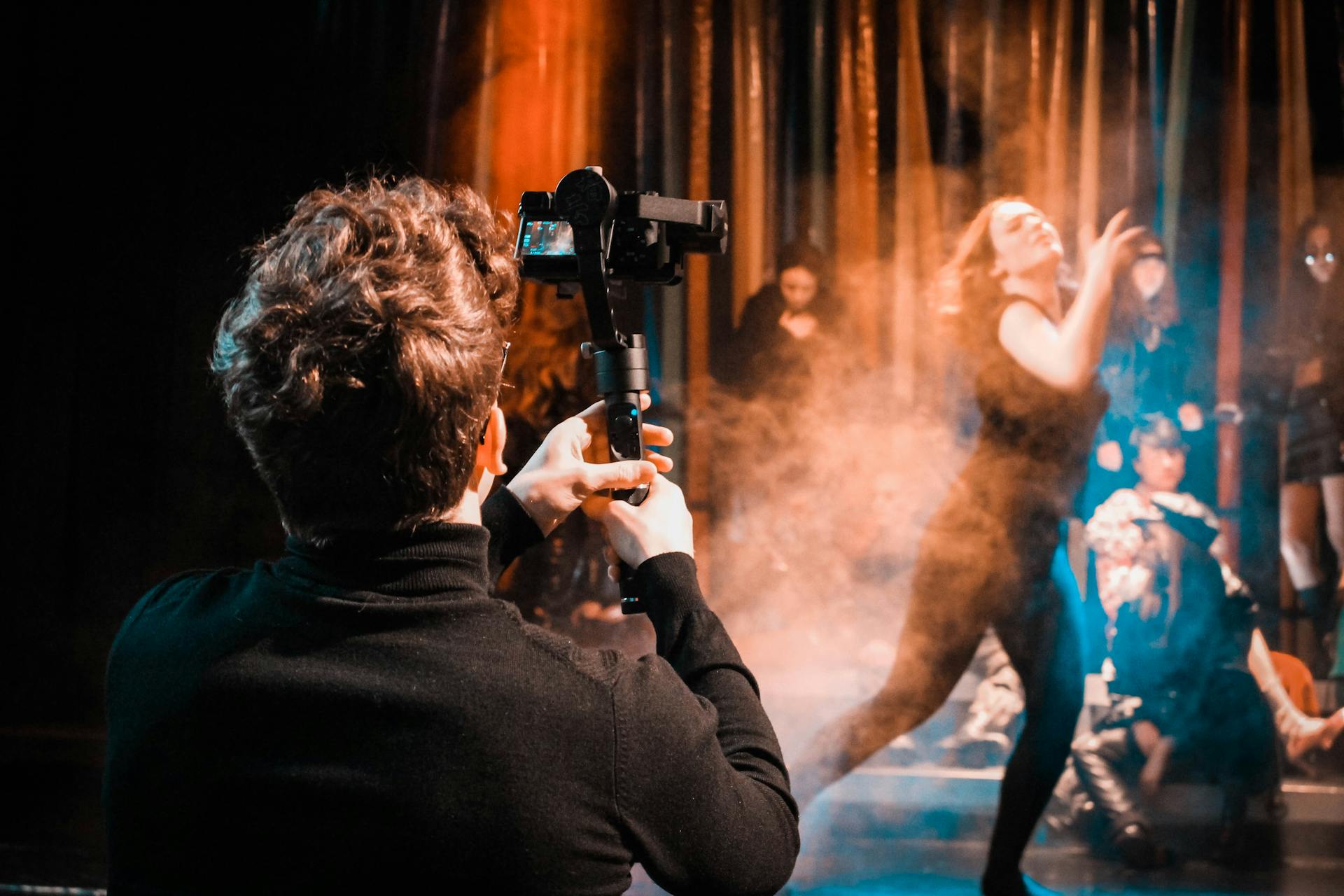 A photographer captures a live dance performance, emphasizing motion and atmosphere on stage.