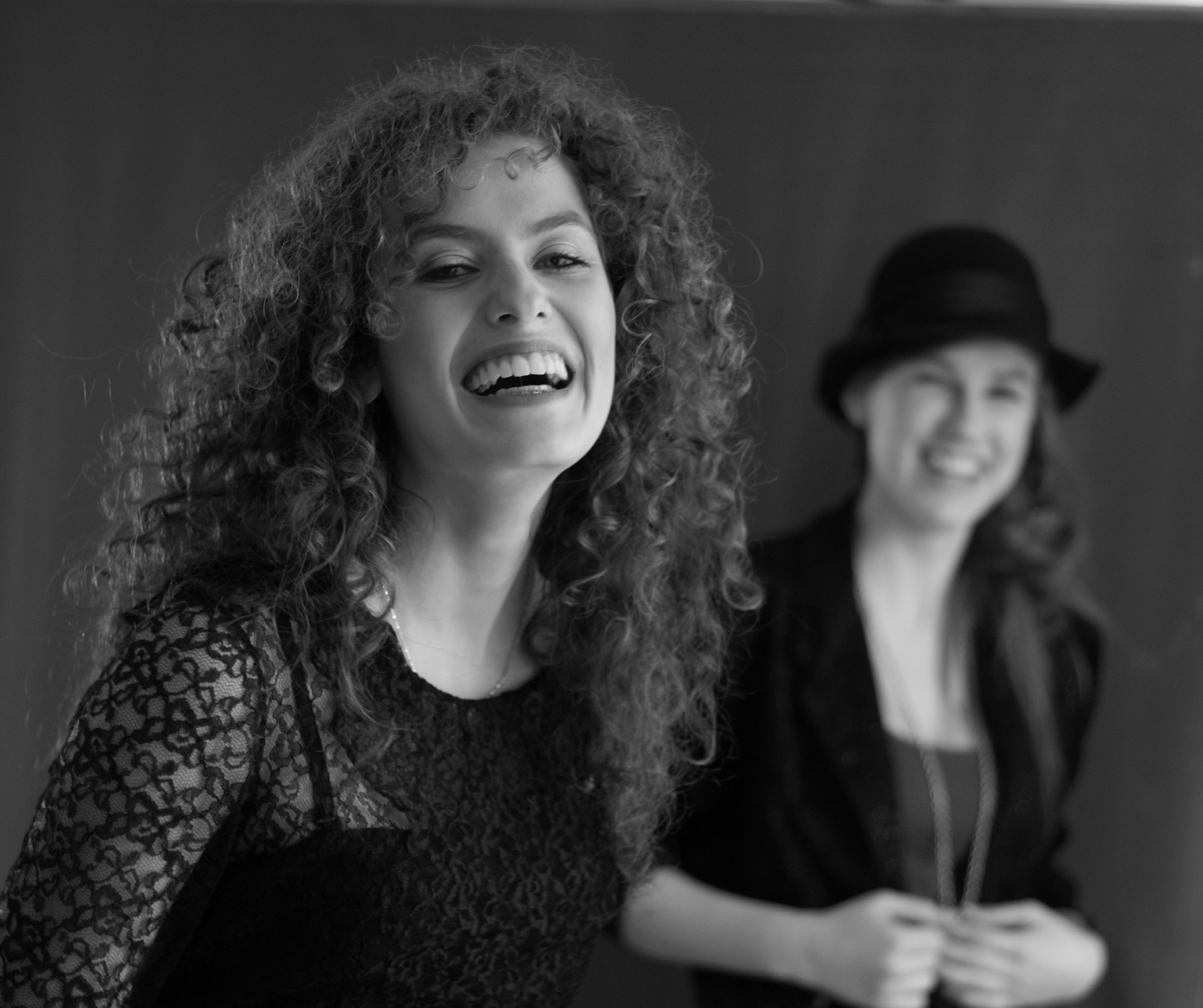 Two women with curly hair laughing together · Free Stock Photo
