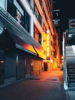 Vibrant urban street in Chicago featuring illuminated neon signs and closed storefronts at night.
