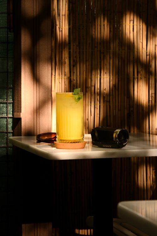 Free A vibrant citrus cocktail with mint garnish, served on a serene bamboo table with ambient lighting. Stock Photo