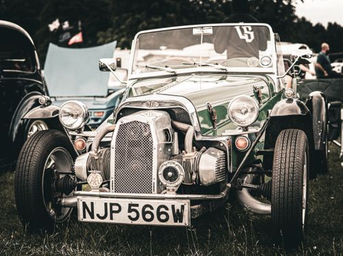 Free A vintage green sports car displayed outdoors at a classic car rally event. Stock Photo