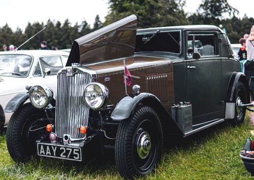 Free Vintage car with open hood displayed at an outdoor gathering, showcasing elegant design and retro style. Stock Photo