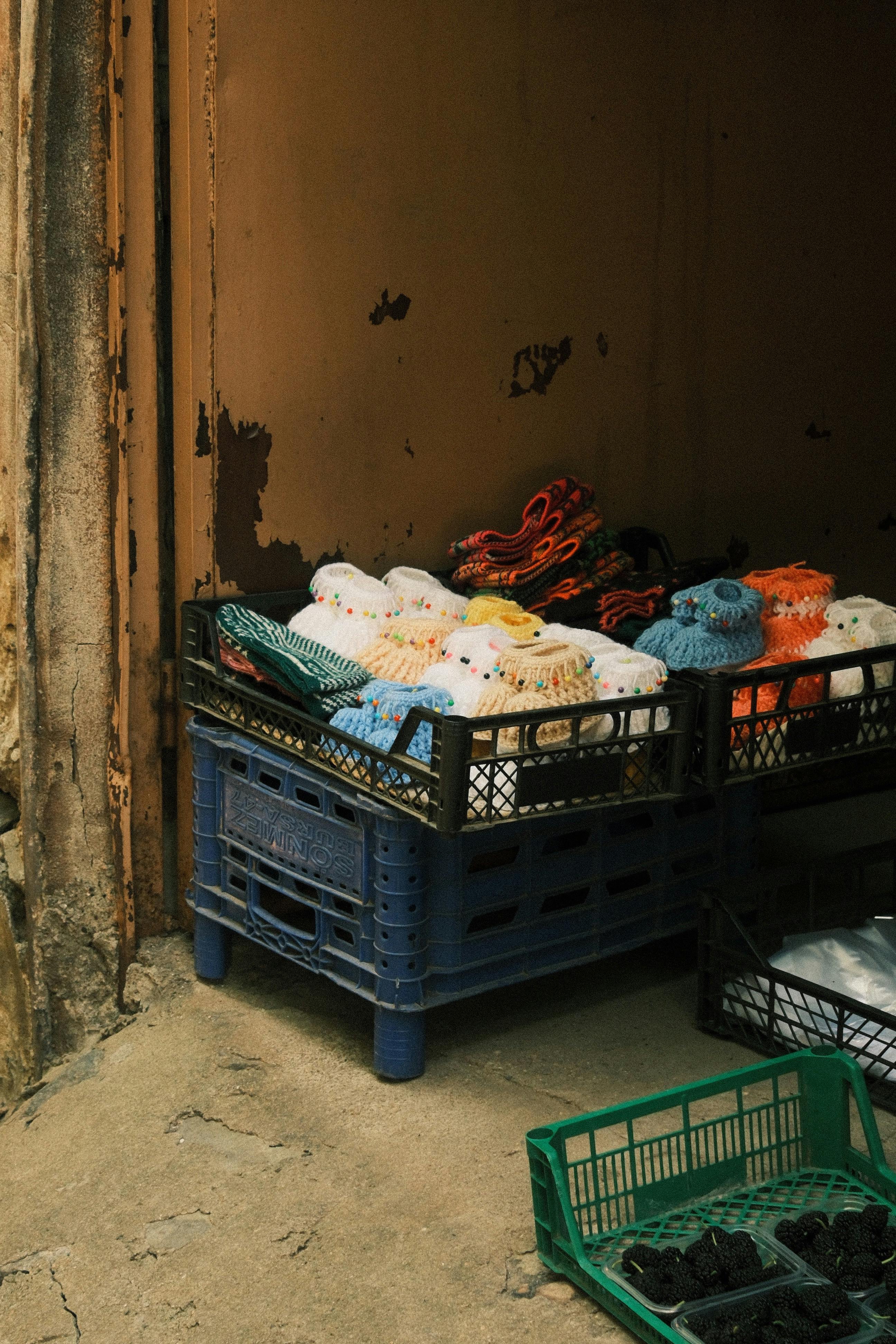A display of colorful crocheted items in crates at Bursa market, Türkiye.