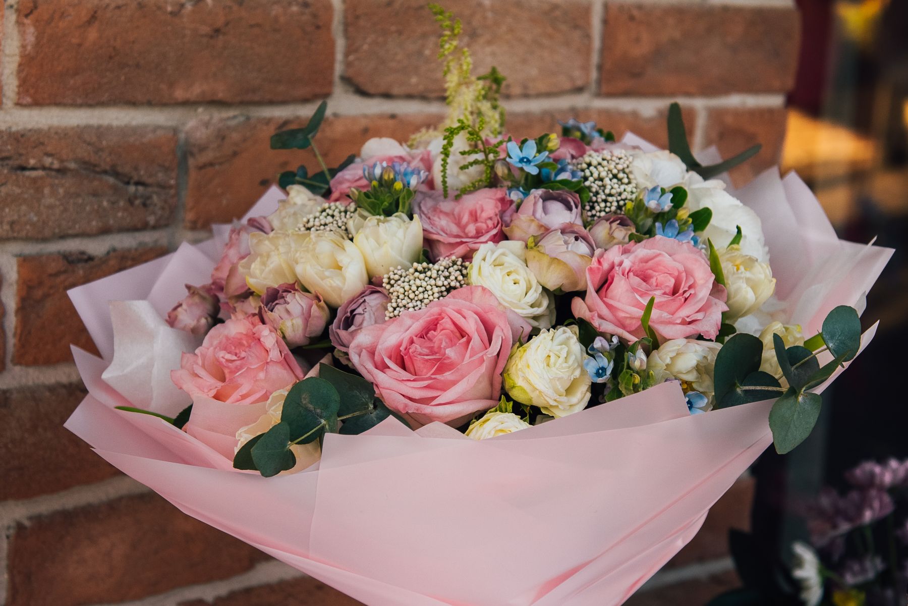 Hand-tied pink and white rose bouquet wrapped in paper