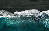 Aerial Photo of Body of Water Crashing into Shore