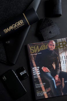 深色时尚的平铺搭配杂志和科技用品，营造出时尚的外观