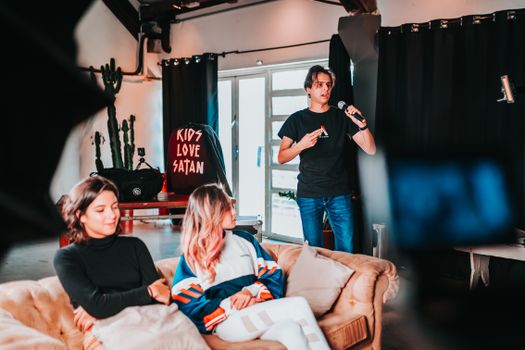 A casual indoor gathering in São Paulo featuring a microphone presentation and relaxed atmosphere.