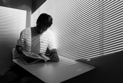 Free Grayscale Photography of a Man Reading Book Stock Photo