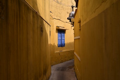 호이안 시의 둘러싸인 노란색 벽에 파란색 창