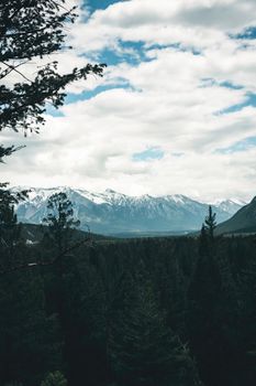 Breathtaking view of snow-capped mountains and lush forest in Banff, Canada.