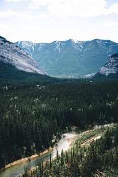 Breathtaking view of Banff National Park with mountains and forested river.
