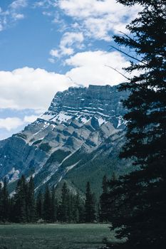 Stunning view of a snow-capped mountain under a blue sky in Banff National Park, Canada.