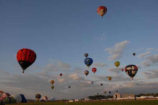 A vibrant display of hot air balloons soaring during a festival with a clear blue sky.