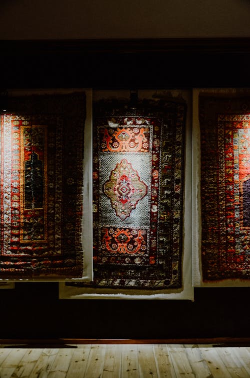 A room with three rugs hanging on the wall