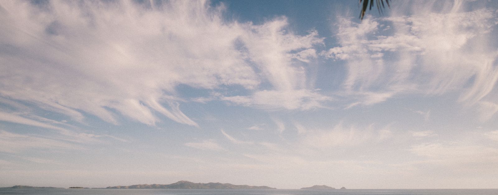 Tranquil ocean scene at Nadi, Fiji with striking clouds and gentle waves.