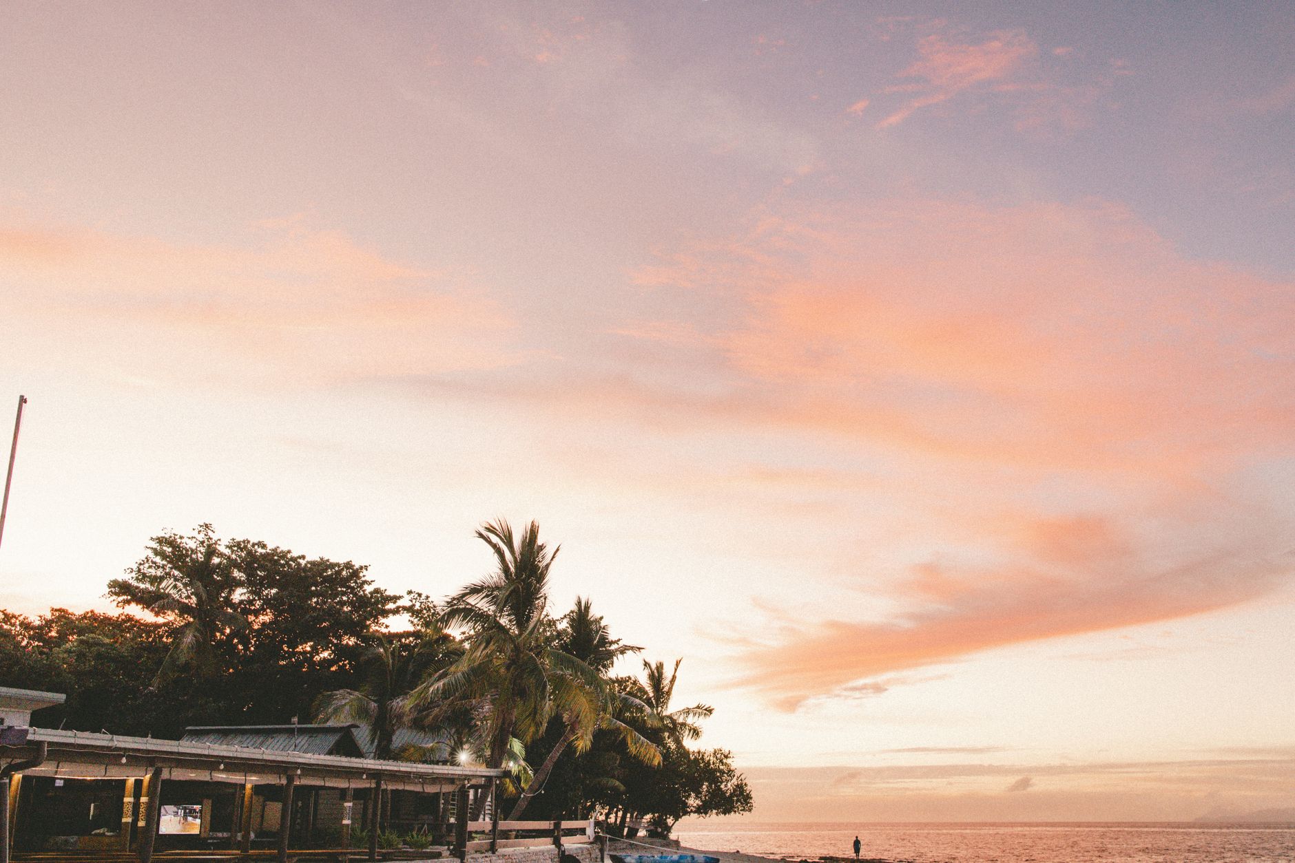 斐濟大溪地手機衛星備援:主流機型可行性實測 A tranquil sunset over a palm tree-lined beach in Nadi, Fiji.
