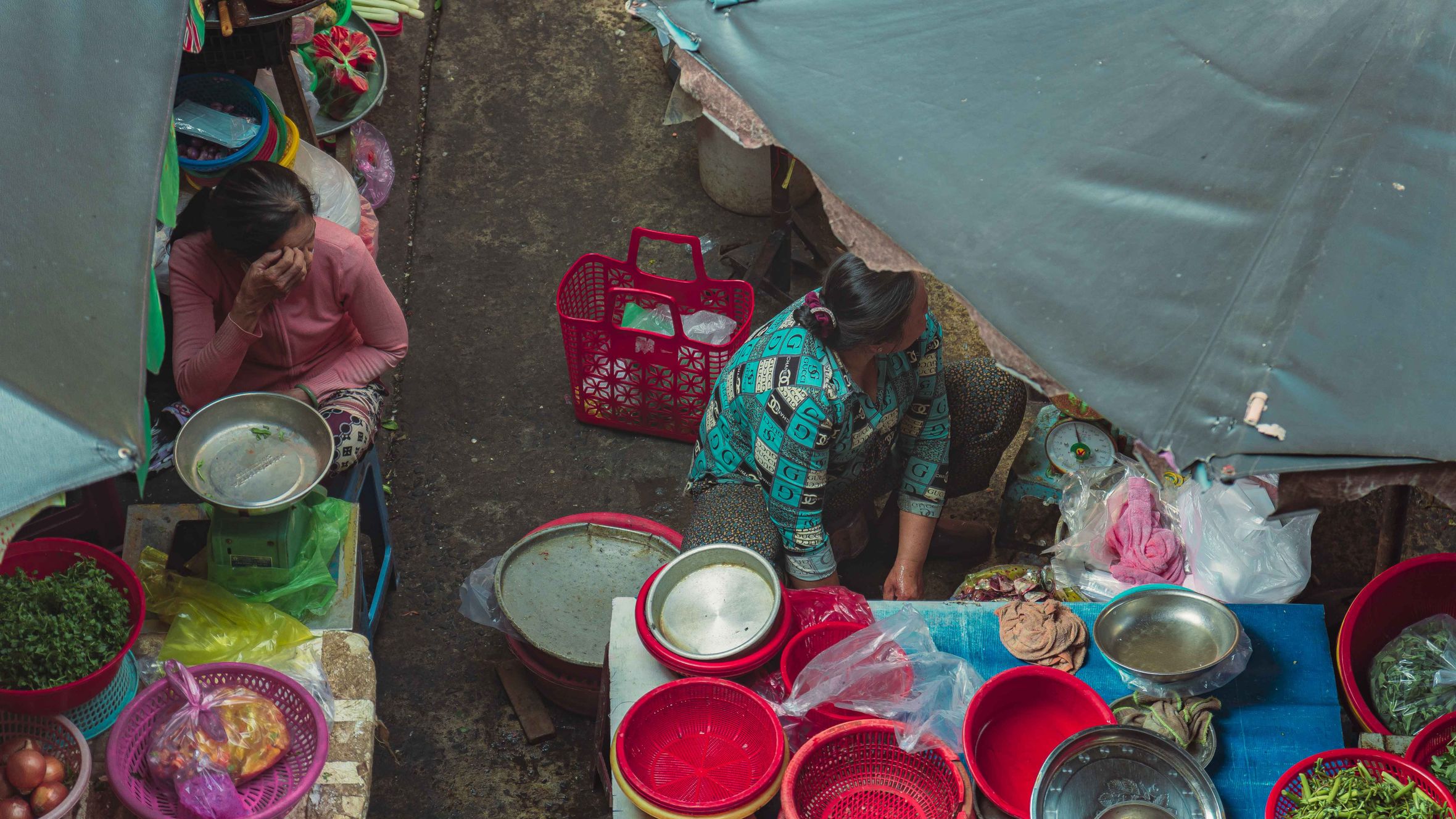View of a bustling street market with vendors and vibrant produce in Ho Chi Minh City, Vietnam.