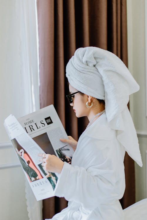 Free A woman in a bathrobe reading a newspaper Stock Photo