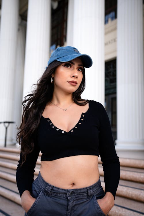 A woman in a crop top and jeans poses for a photo