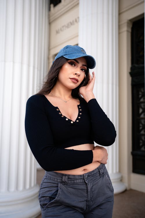 A woman in a crop top and jeans poses for a photo