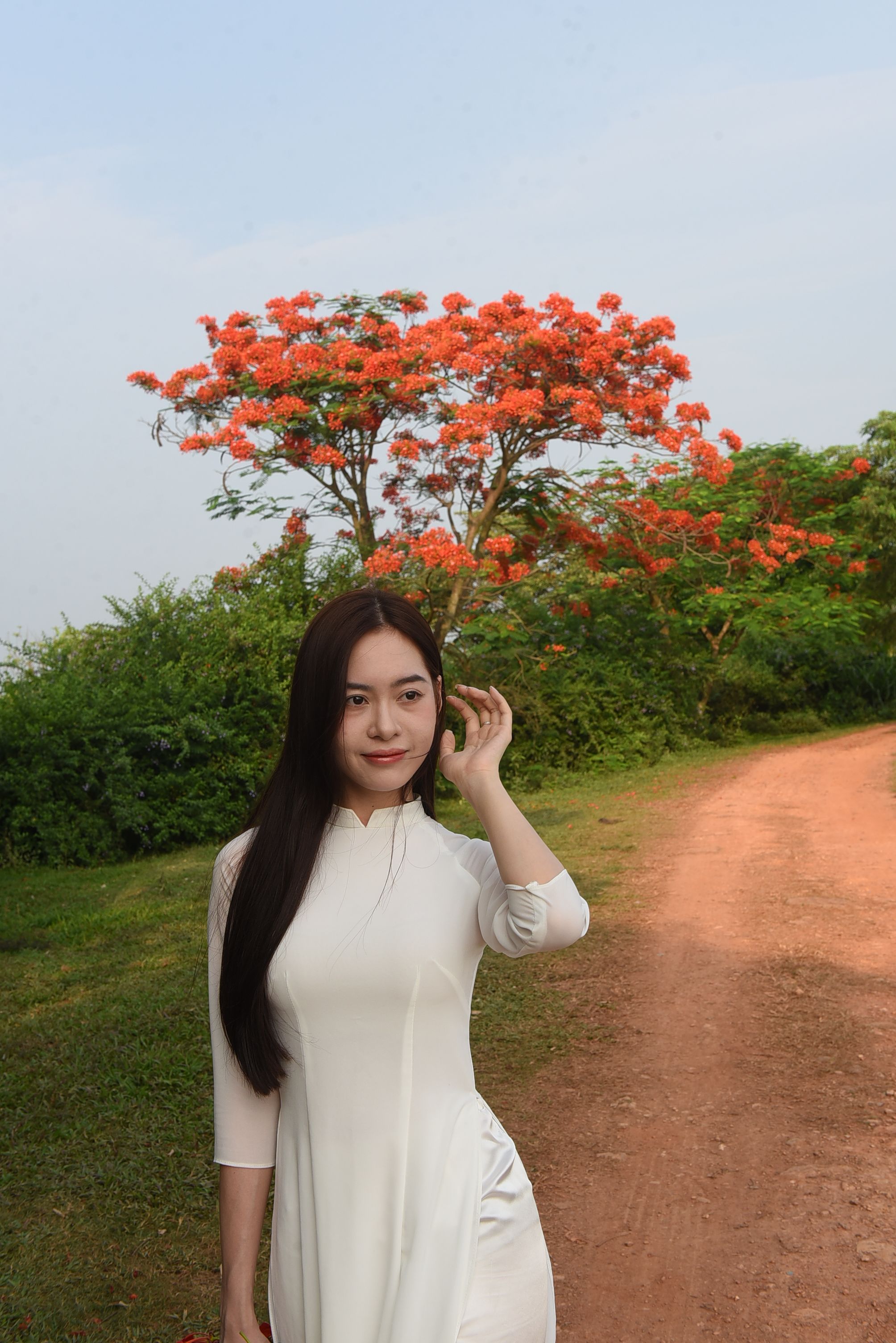A woman in a white dress posing in front of a tree · Free Stock Photo
