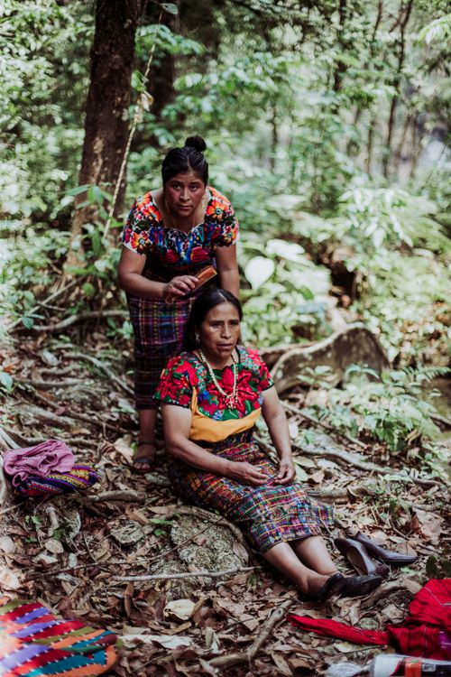 Free Women in vibrant traditional clothing enjoying leisure time in a forest setting. Stock Photo