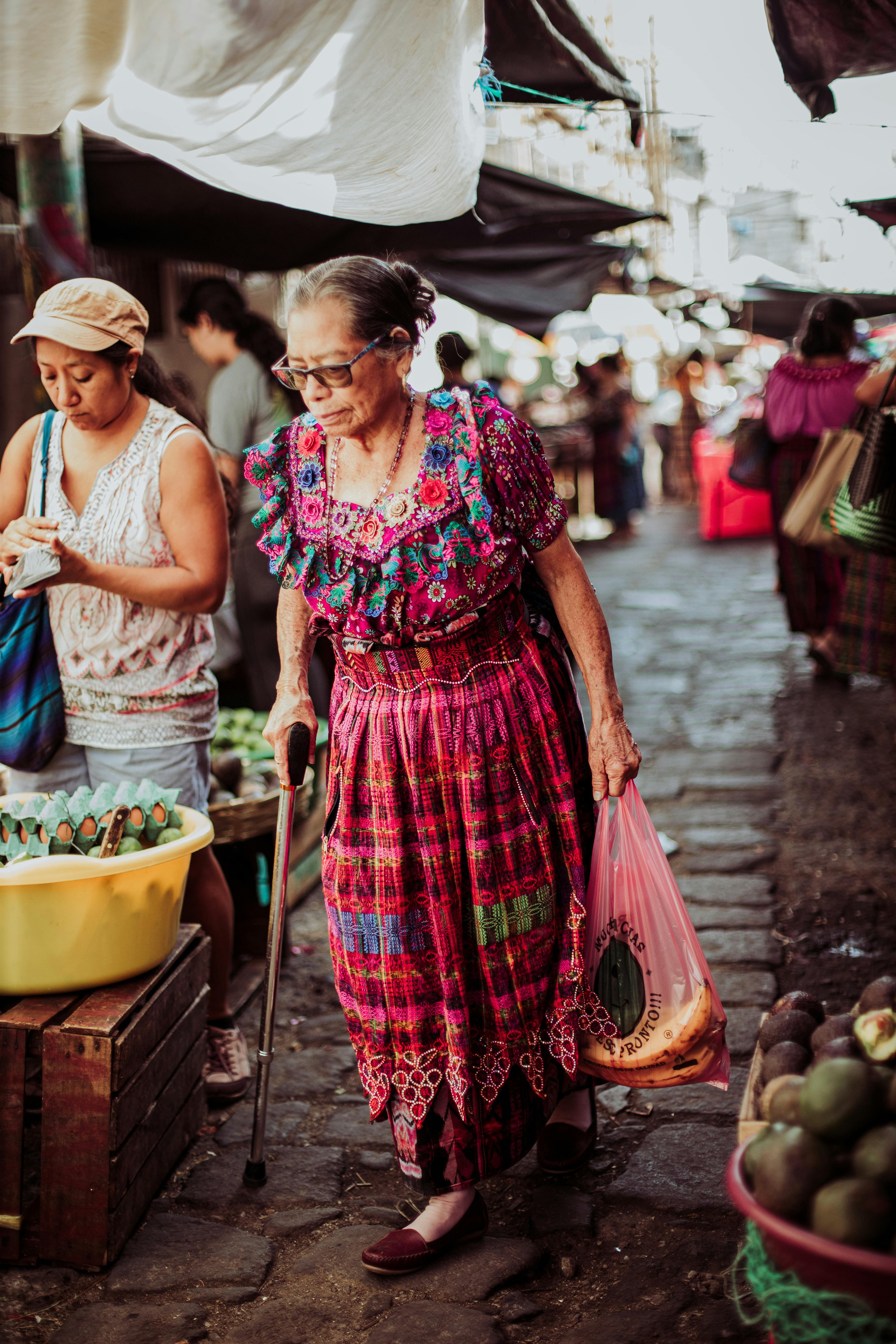 Vibrant scene of a woman shopping at a traditional outdoor market.