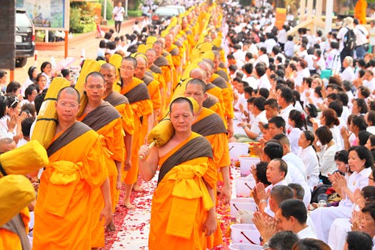 Vibrant procession of Buddhist monks and community in traditional Thai ceremony, Bangkok.