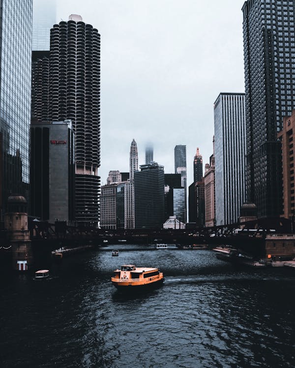 Boat on Body of Water Near Buildings of the City