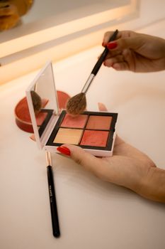 A close-up shot of a makeup palette and brush in use, highlighting vibrant colors.
