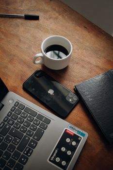 A minimalistic desk setup featuring a laptop, smartphone, and a cup of coffee.