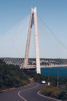 一座令人惊叹的斜拉桥耸立在蜿蜒的道路和水道之上，非常适合作为旅行照片的背景