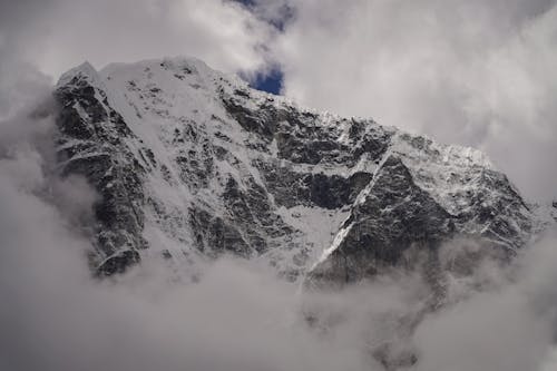 Foto Gunung Yang Tertutup Salju Dikelilingi Awan