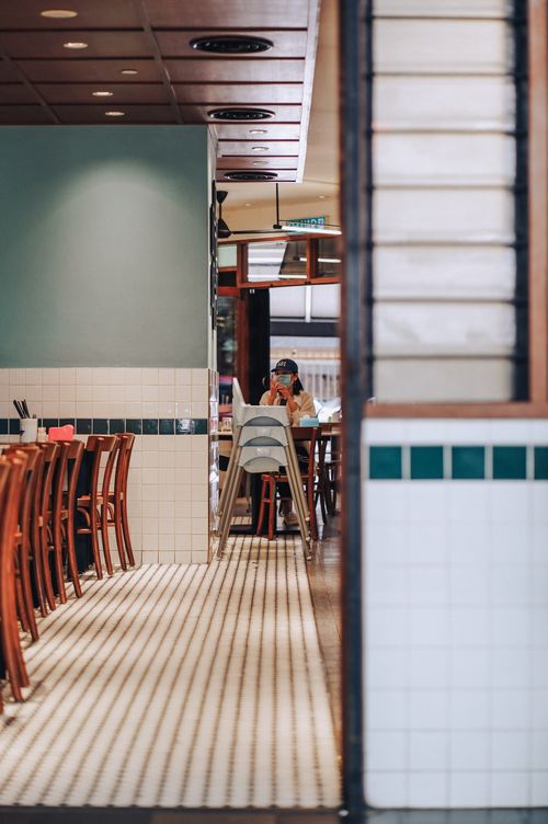 Free Inviting dining area with wooden chairs and tiled flooring, capturing a cozy restaurant atmosphere. Stock Photo