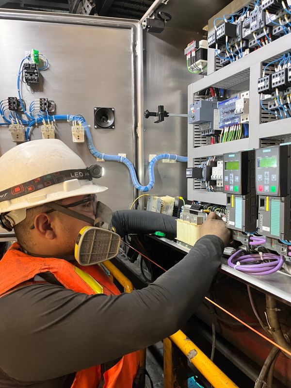 Electrician adjusting wires on a control panel
