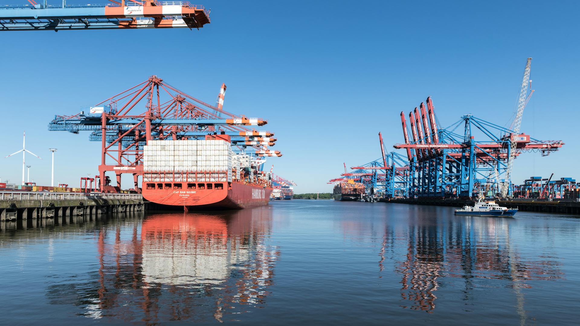 Large container ship moored at Terminal Burchardkai in Hamburg, showcasing logistics and iconic port views.