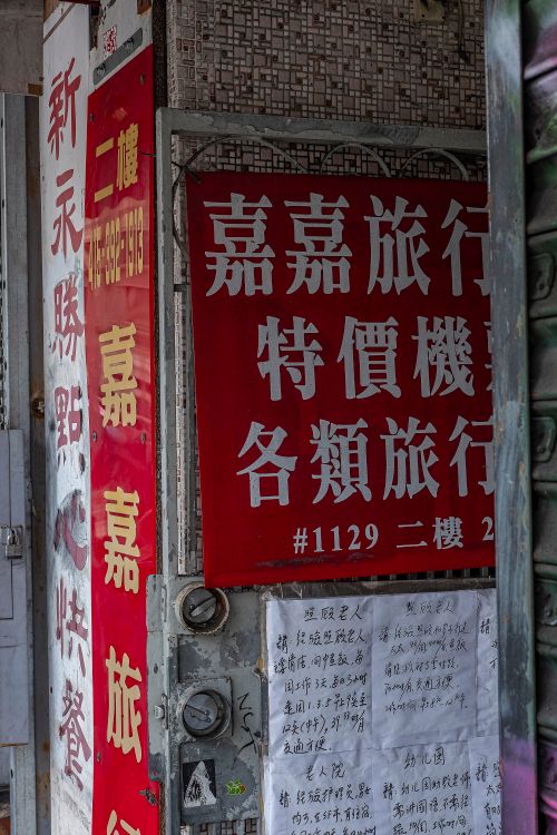 Free Close-up of urban posters and signs with Chinese text on a city wall. Stock Photo