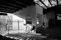 这张黑白照片里，一座废弃建筑中有一个空荡荡的旧售票亭，阴影很重