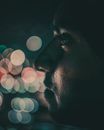 一名男子在夜间佩戴彩色散景灯，侧面轮廓显得很有氛围