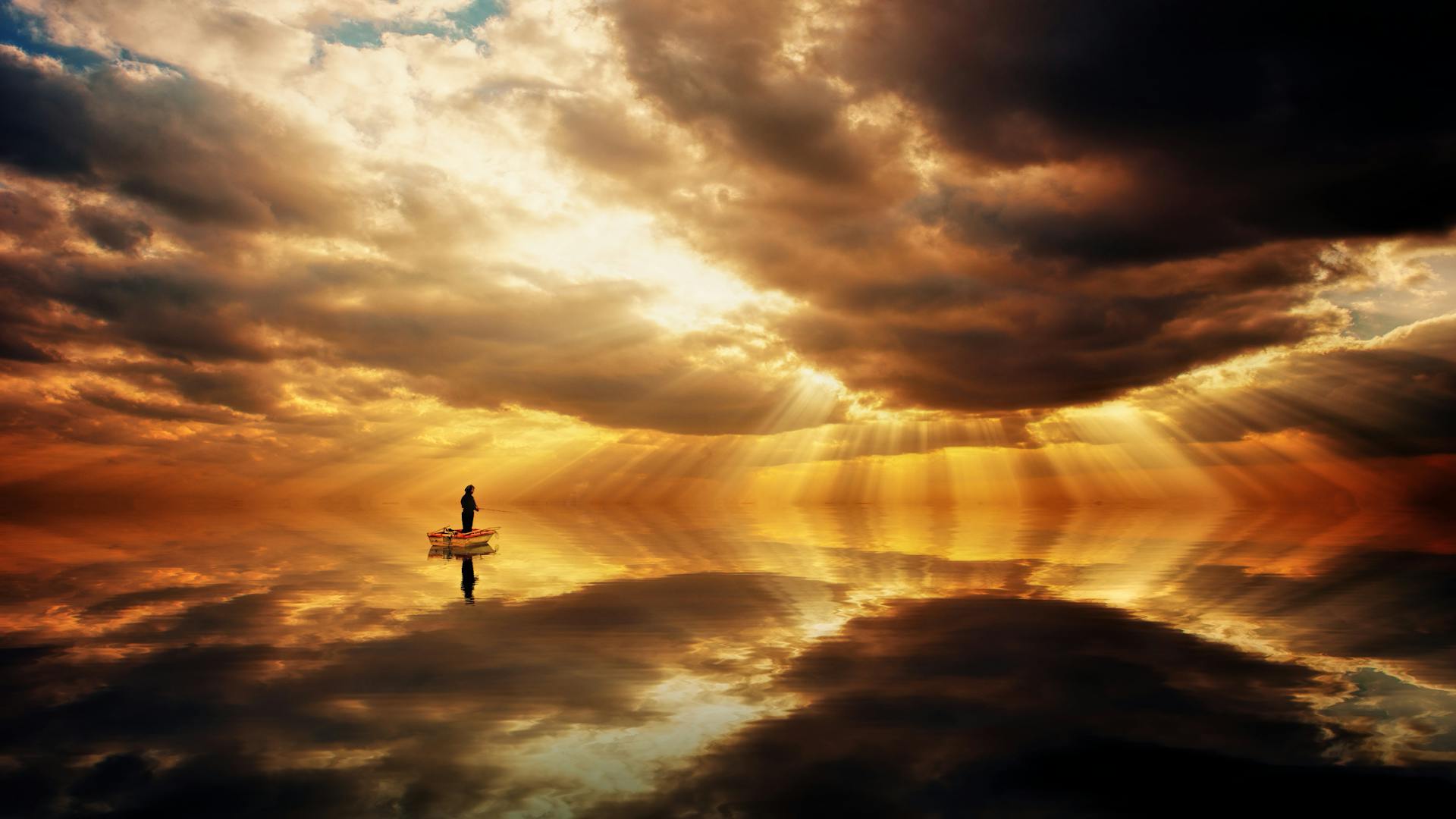 Silhouette of a Person Standing in a Boat on a Calm Body of Water under a Dramatic Sunset Sky