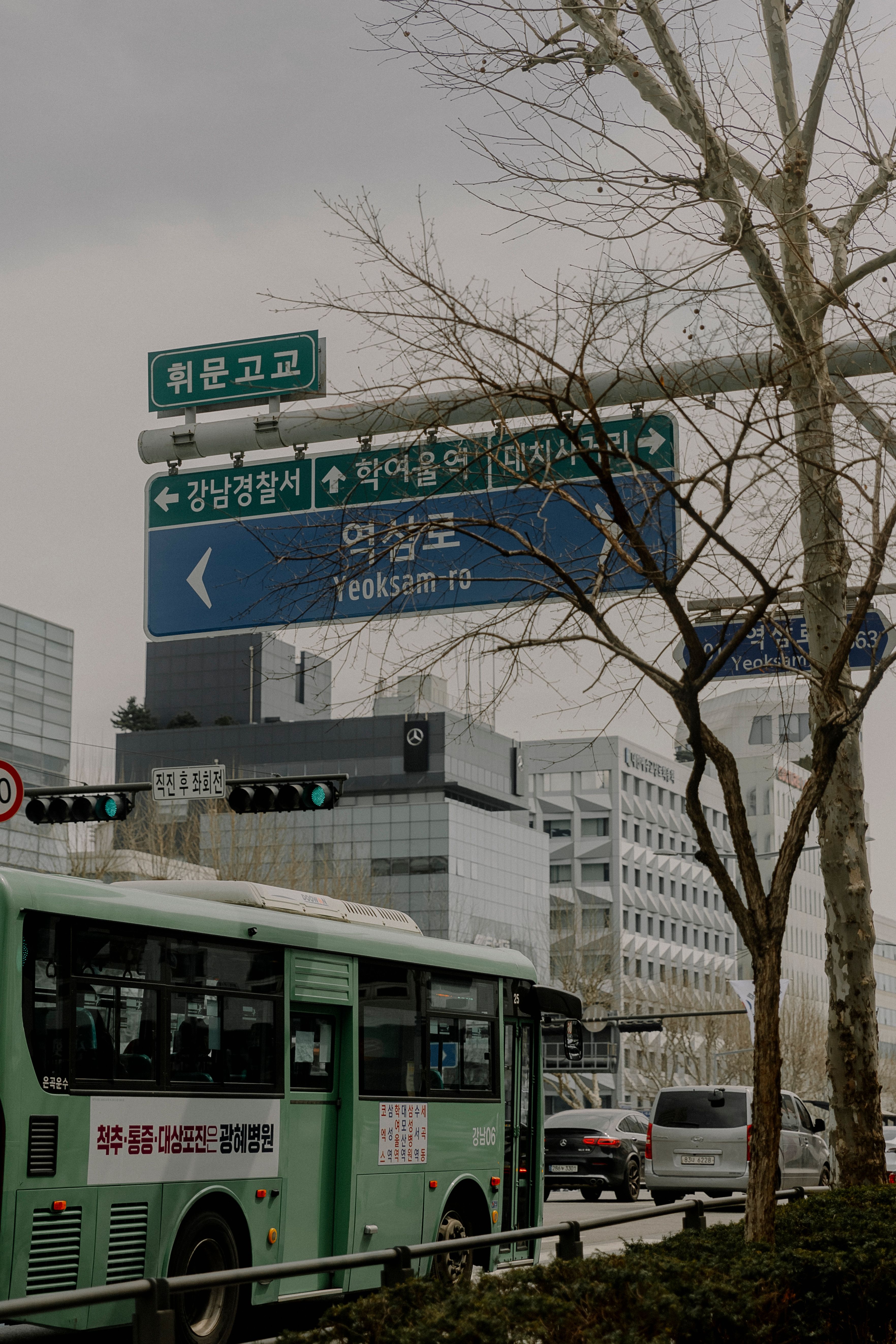 Busy urban street with buses and signs in Yeoksam-ro, Seoul, South Korea.