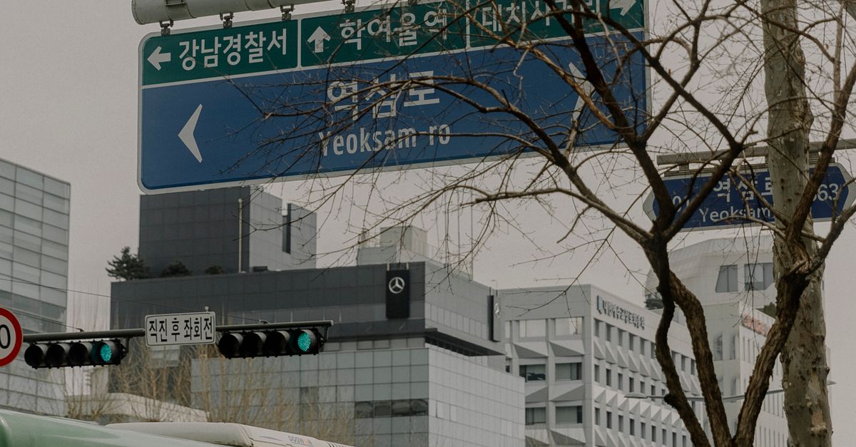 Busy urban street with buses and signs in Yeoksam-ro, Seoul, South Korea.