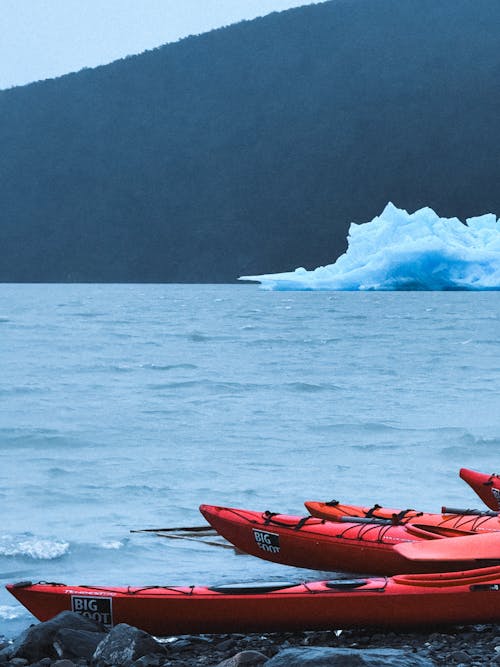 Free Kayaks on the water with an iceberg in the background Stock Photo