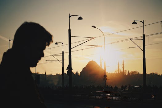 Silhouette of a man against a city skyline at sunset, capturing an urban atmosphere.