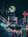 热闹的夜市街道上，霓虹灯标志和人群充满活力，照亮了整条街